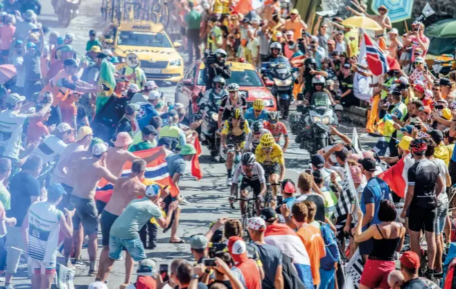  ??  ?? On the podium in Paris last summer, flanked by team-mate Froome, and Dumoulin
Thomas rides through the flares on Alpe d’Huez on his way to a Tour win last year