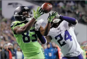  ?? AP PHOTO/TED S. WARREN ?? Seattle Seahawks receiver David Moore (83) reaches for the ball as Minnesota Vikings' Holton Hill defends near the end of the first half of an NFL football game, Monday in Seattle. Moore made the catch but was ruled out of bounds.