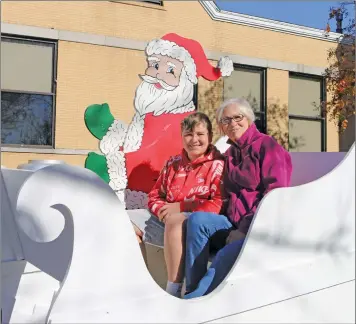  ?? ELISHA MORRISON/THE Saline Courier ?? Jackie Flannery and her grandson Sam Cookhan, 14, pose for a photo in Santa’s Sleigh on the Saline County Courthouse lawn. Benton will be hosting various Christmas events around town for the holidays.