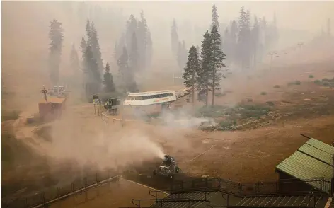  ?? Photos by Brontë Wittpenn / The Chronicle ?? A snow maker drenches a slope-facing patio in efforts to protect it from the Caldor Fire at Sierra-at-Tahoe ski resort.