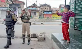  ?? — PTI ?? A boy plays with security force jawans during a curfew in Srinagar on Saturday.