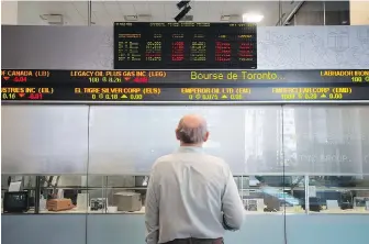  ?? DARREN CALABRESE, THE CANADIAN PRESS ?? A man watches the financial numbers on the digital ticker tape at the TMX Group in Toronto’s financial district, May 9, 2014.