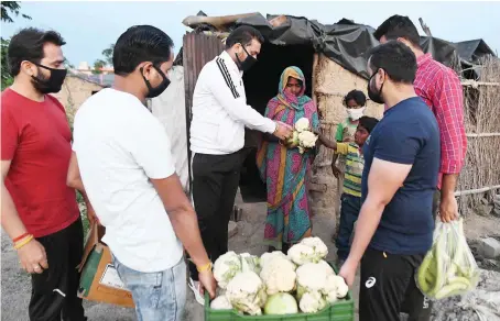  ?? AFP ?? Volunteers distribute food to people in need during a government-imposed nationwide lockdown as a preventive measure on the outskirts of Amritsar on Wednesday.