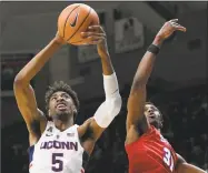  ?? Jessica Hill / Associated Press ?? UConn’s Isaiah Whaley, left, grabs a rebound over SMU’s Jimmy Whitt during their game on Jan. 25 in Storrs. The teams will meet again on Thursday in the AAC Tournament.