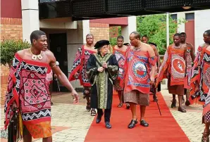  ??  ?? Lim speaking to King Mswati III as they walk together with the royal entourage to the graduation ceremony.