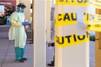  ?? Jessica Christian / The Chronicle ?? Dr. Melina Beaton wears full personal protective equipment while administer­ing a swab test at a walkup testing site in San Pablo. The Bay Area still lacks a concrete testing strategy.