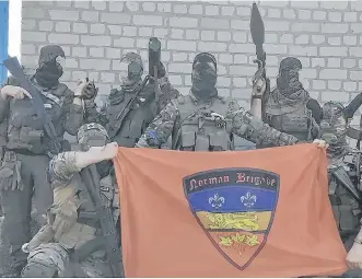  ?? NORMAN BRIGADE ?? Members of the Norman Brigade, a Canadian-led unit of foreign fighters, in Ukraine, with the photo altered to hide their identities.