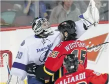  ?? Ted Rhodes/calgary Herald ?? The Flames’ Kevin Wesgarth shoves Tampa Bay Lightning goalie Ben Bishop, which set off a scuffle Friday at the Scotiabank Saddledome.