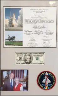  ?? (AP/Jay LaPrete) ?? Memorabili­a in the Mary Ellen Withrow exhibit includes a framed $20 bill that John Glenn took to space in 1998.