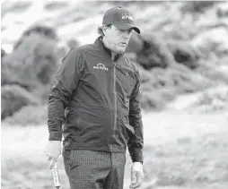  ?? CLIFF HAWKINS/GETTY ?? Despite several difficulti­es, Phil Mickelson managed to grab a share of the lead Friday in the rain-shortened second round of the AT&amp;T Pebble Beach Pro-Am.