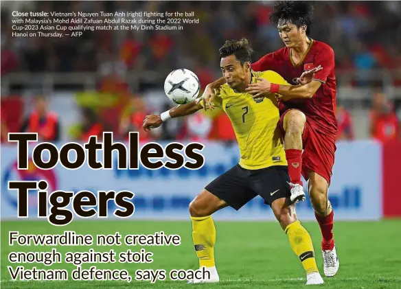  ??  ?? Close tussle: Vietnam’s Nguyen Tuan Anh (right) fighting for the ball with Malaysia’s Mohd Aidil Zafuan Abdul Razak during the 2022 World Cup-2023 Asian Cup qualifying match at the My Dinh Stadium in Hanoi on Thursday.