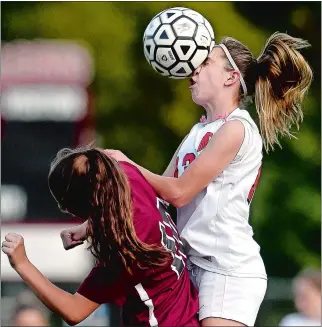  ?? TIM MARTIN/THE DAY ?? Fitch’s Morgan Bates, right, attempts to head the ball against East Lyme’s Alivia Catanzaro during Wednesday’s girls’ soccer match at Poquonnock Plains Park in Groton. East Lyme won 4-0.