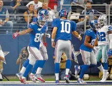  ??  ?? New York Giants receiver Victor Cruz, left, celebrates his fourth-quarter touchdown catch with quarterbac­k Eli Manning on Sunday in Dallas.