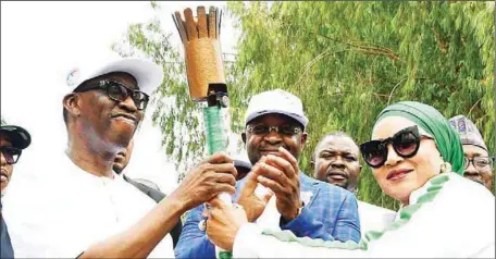  ?? ?? Caption Delta Governor and Vice Presidenti­al Candidate of the PDP, Senator Dr Ifeanyi Okowa ( left) receiving the Touch of Unity from Chief Amaka Ashiofu, chairman, Touch of Unity, Delta 2022, ahead of the 21st edition of the National Sports Festival in Government House, Asaba on Tuesday as the Hon. Minister of Youths and Sports Developmen­t , Chief Sunday Dare,( middle) applauds in admiration.