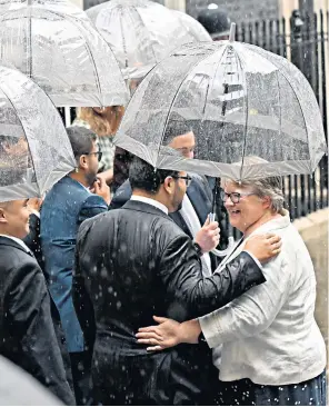 ?? ?? Liz Truss entering No 10 yesterday, left. Therese Coffey, above, the new Deputy PM, was caught in the rain, which almost overshadow­ed proceeding­s and prompted a scowl from one Downing Street onlooker, below