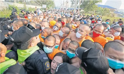  ??  ?? Monks and officers from the Department of Special Investigat­ion clash in a scuffle yesterday morning as the monks tried to push back the authoritie­s outside Wat Phra Dhammakaya near Khlong Luang Road.