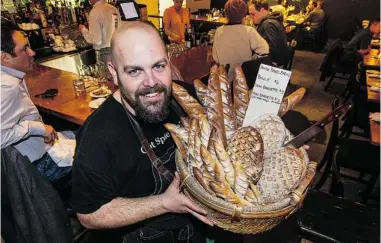  ?? PHOTOS: STEVE BOSCH/ PNG ?? Josh Wolfe shows off a basket of bread at Good Wolfe Restaurant in Yaletown. It’s an inviting place, says our reviewer.