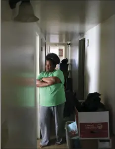  ??  ?? In this Thursday photo, Tara Adams poses for a portrait in her home as boxes sit stacked in a hallway waiting for an impending move from her East Chicago, Ind., home. AP PHOTO/CHARLES REX ARBOGAST