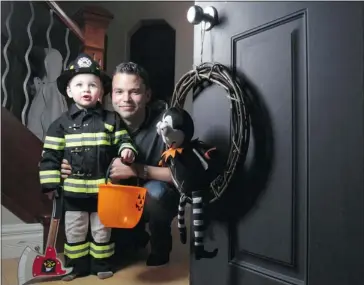  ?? Leah Hennel/calgary Herald ?? Shane Byciuk and his two-year-old son, Kyron, expect as many 200 trick-or-treaters at their Cranston home tonight.