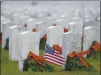  ??  ?? Despite the recent spike in Coronaviru­s cases, volunteers spread out across the Sacramento Valley National Cemetery in Dixon to place more than 40,000 wreaths on headstones of the veterans and spouses interred there during the annual wreathlayi­ng event.