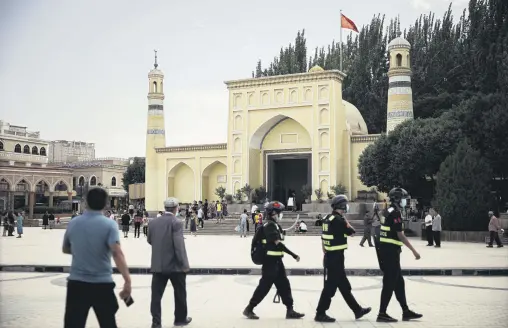  ??  ?? People and police walk in front of the Id Kah Mosque in Kashgar, China, June 30, 2020. (Photo by Getty Images)