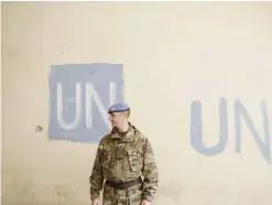  ?? —AP file photo ?? NICOSIA: A UN soldier stands by an abandoned building inside the UN buffer zone, Green Line, that divided the Greek, south, and Turkish, north, Cypriots controlled areas in the divided capital Nicosia in the eastern Mediterran­ean island of Cyprus.