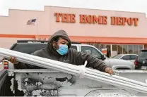  ?? Jason Fochtman / Staff photograph­er ?? A man loads PVC pipes to repair a broken pipe at his home. One prediction said the storm will likely cost the country $50 billion.