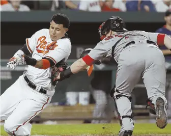  ?? AP PHOTO ?? GOTCHA: Manny Machado is tagged out by Red Sox catcher Christian Vazquez as he tries to score in the second inning of last night's game in Baltimore.