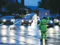  ?? (David Mariuz/Reuters) ?? POLICE DIRECT traffic in the central business district of Adelaide after severe storms and thousands of lightning strikes knocked out power to the entire state of South Australia yesterday.