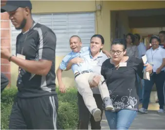  ?? ANEUDY TAVÁREZ ?? Dos docentes cargan a un niño en medio de las tareas del simulacro.