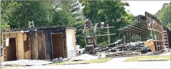  ?? Westside Eagle Observer/MIKE ECKELS ?? The last of the ceiling rafters on the burned-out chicken shack at Veterans Park come down June 13 to make way for a new structure. A new chicken shack is expected to be completed on the site by the 2018 Decatur Barbecue on Aug. 4.