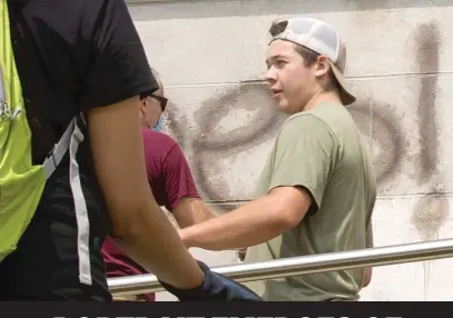  ?? PAT NABONG/SUN-TIMES ?? Kyle Rittenhous­e helps clean the exterior of Reuther Central High School on Tuesday morning in Kenosha. Hours later, he allegedly shot three protesters, two of them fatally.