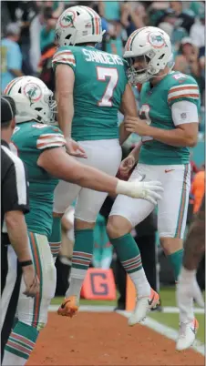  ?? THE ASSOCIATED PRESS FILE ?? Miami Dolphins kicker Jason Sanders (7) and punter Matt Haack (2) celebrate after Sanders scored a touchdown thrown by Haack during the first half of a game against the Eagles Dec. 1 in Miami Gardens, Fla.