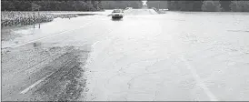  ?? (DDD File Photo) ?? A deluge of rain hit Adams County Monday bringing nearly 2.5 inches of the wet stuff to the Decatur and Adams County area causing flooding of many Adams County roads. Law enforcemen­t officials reported two accidents occurred Tuesday caused by vehicles trying to navigate the water such as the vehicle here is doing. They pleaded with drivers to use extra safety when driving conditions become hazardous on the roads.