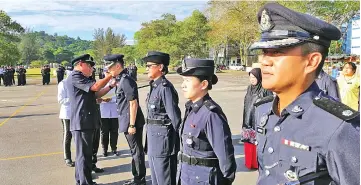  ??  ?? Lim pins the stripe on a promoted recipient in conjunctio­n with the 212th Police Day at IPD Miri yesterday.