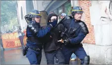  ?? AP PHOTO ?? Riot police officers detain a protester during a demonstrat­ion in Paris yesterday.