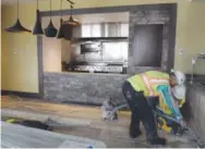 ??  ?? Constructi­on crews put on the finishing touches in the kitchen area of the Hilton Garden Inn this month.