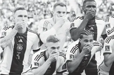  ?? ?? Germany players cover their mouths as they pose for a team group photo before the match REUTERS/Annegret Hilse