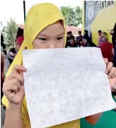  ??  ?? An evacuated student shows her drawing about what she and other Marawi residents experience­d before fleeing the city still under siege during a school day at Pantar elementary school in Lanao Del Norte, Philippine­s June 6, 2017. REUTERS/Neil Jerome...