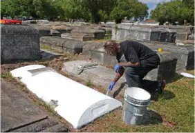  ?? AP PHOTO/MARTA LAVANDIER ?? Frank Wooden paints a grave Feb. 26 at the Lincoln Memorial Park Cemetery in the Brownsvill­e neighborho­od of Miami.