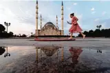  ??  ?? A woman walks past the Heart of Chechnya mosque in central Grozny .