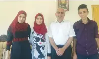  ?? (Adam Rasgon) ?? RAHAF MUFEED ABDULLAH (second left), who received the highest score on the Palestinia­n national standardiz­ed test, poses for a photo with her family.