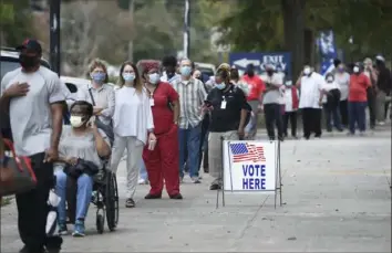  ?? Michael Holahan/The Augusta Chronicle via AP ?? Voters wait in line to cast their ballots early Monday at Bell Auditorium in Augusta, Ga.