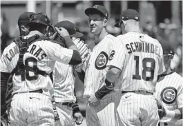  ?? NAM Y. HUH/AP ?? Cubs starting pitcher Drew Smyly, center, listens to pitching coach Tommy Hottovy during the first inning Saturday at Wrigley Field.