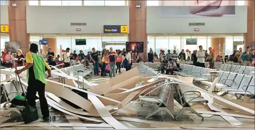  ??  ?? KALI KEDUA: Petugas Bandara Supadio, Pontianak, mengumpulk­an serpihan plafon yang ambrol di ruang tunggu penumpang kemarin. Kejadian itu melukai 4 orang di ruang tunggu.
