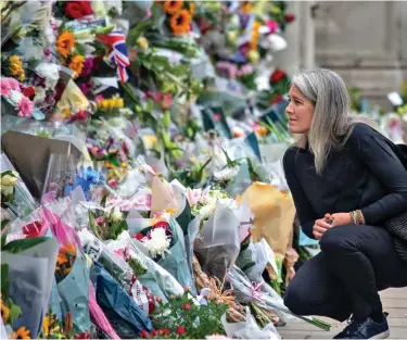  ?? ?? Public grief: Floral tributes at royal residences are symbolic of our grieving nation