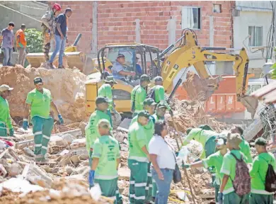  ?? — Gambar AFP ?? PEKERJA Syarikat Pembersiha­n Niteroi membersihk­an kawasan yang dijejas tanah runtuh yang berlaku pada awal pagi selepas hujan lebat di bandar Niteroi, Rio de Janeiro kelmarin.