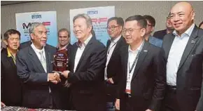  ?? PIC BY OWEE AH CHUN ?? Deputy Entreprene­urial Developmen­t Minister Dr Mohd Hatta Md Ramli (second from left) receiving a souvenir from Malaysian Retail Chain Associatio­n president Datuk Seri Garry Chua in Kuala Lumpur yesterday.