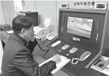  ?? South Korea Unificatio­n Ministry/Yonhap via AP ?? A South Korean government official communicat­es with a North Korean officer Wednesday during a phone call on the dedicated communicat­ions hotline at the border village of Panmunjom in Paju, South Korea. A Seoul official says both Koreas have agreed to...