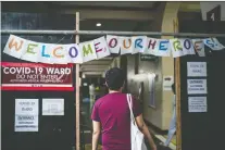  ?? MARTIN SAN DIEGO/THE WASHINGTON POST ?? An employee enters Philippine General Hospital to begin a shift in the coronaviru­s ward.